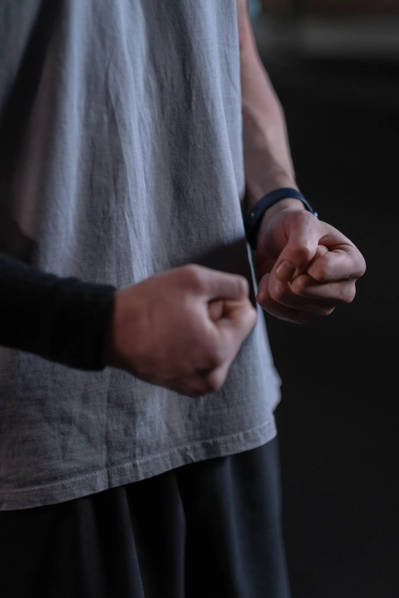A boxer's wrapped hands ready at the sides