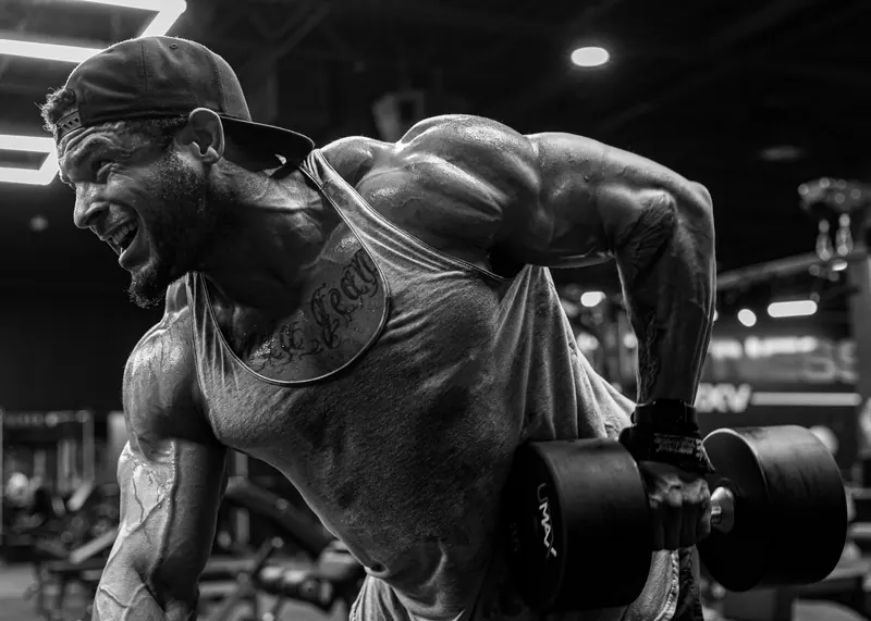 A lifter mid-row with a heavy dumbbell