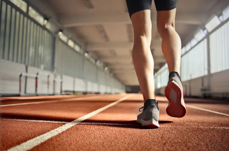 Runner's legs on an indoor track